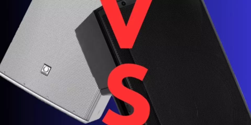 The image displays two speakers placed against a blue background, with a large red letter 'V' and 'S' on either side, suggesting a versus or comparison theme. On the left side is a white speaker, which has a clean and modern design with a visible logo on the lower part. On the right side is a black speaker with a rugged design and a logo at the bottom right corner. The overall composition suggests a comparison or competition between the two speaker models or brands.